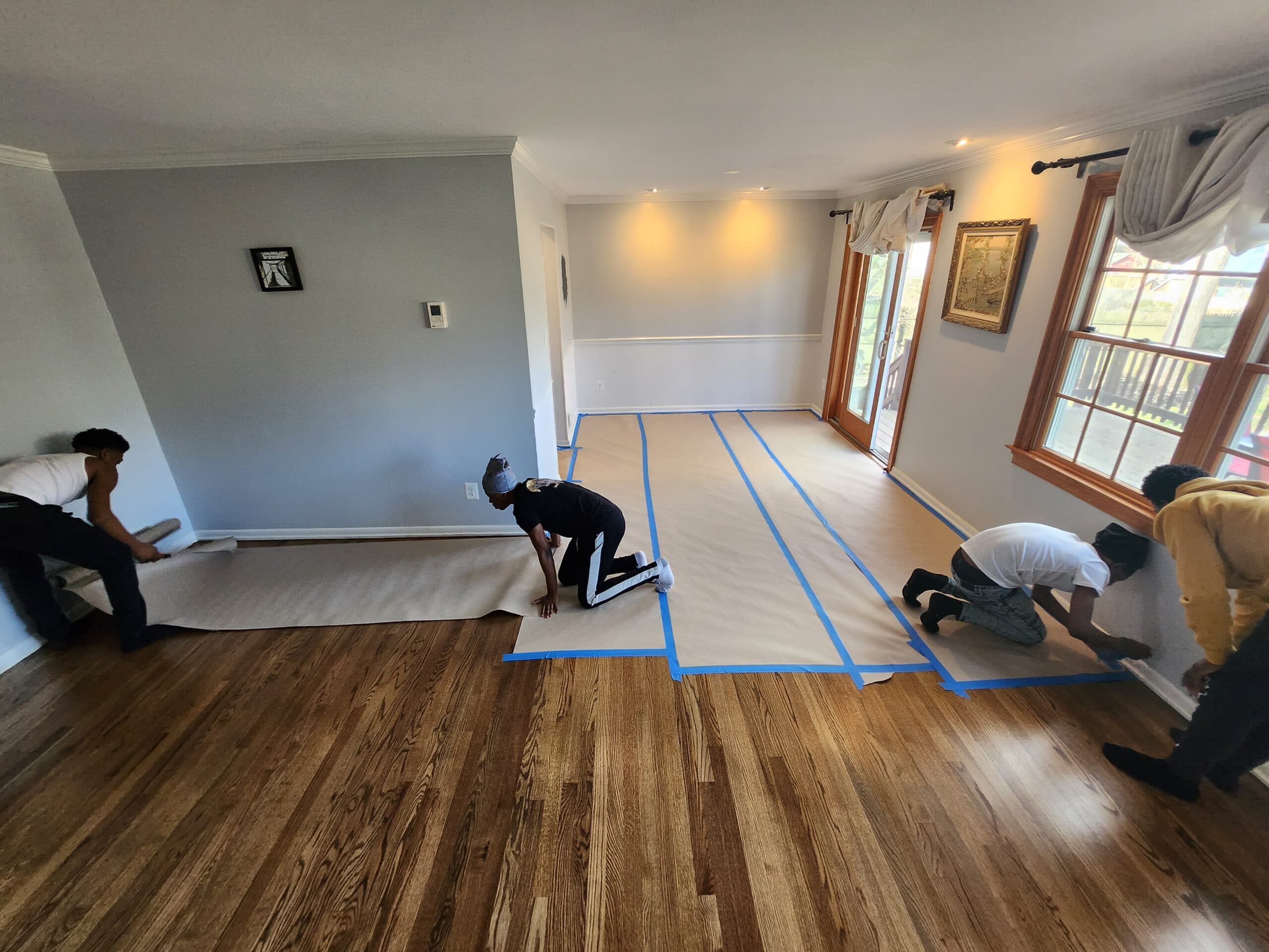 Apprentices preparing the room to be painted.